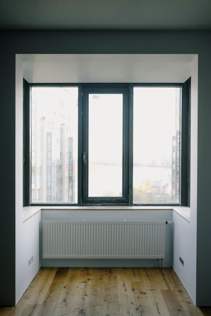 Voorbeeld: radiator onder een breed raam in een lege kamer